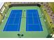 Aerial shot of vibrant blue tennis courts, complete with lighting and seating for players and spectators alike at 739 Marlay Sw Ln, Powder Springs, GA 30127