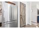 Bright kitchen showcasing a stainless steel fridge and a rustic, wooden barn-style pantry door at 91 East Meadow Ln, Conyers, GA 30012