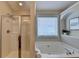 Bathroom includes separate glass shower stall and soaking tub with tile surround and updated fixtures at 2505 Thackery Ct, Cumming, GA 30041