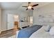 Bright bedroom with vaulted ceiling, wood floors, ceiling fan, and open door to a bathroom at 2505 Thackery Ct, Cumming, GA 30041
