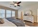 Bright bedroom featuring wood floors, a ceiling fan, and an ornate dresser with large mirror at 2505 Thackery Ct, Cumming, GA 30041