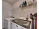 Well-equipped laundry room with modern washer, dryer, and ample storage space on shelving at 2505 Thackery Ct, Cumming, GA 30041