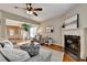 Bright open living room features a fireplace, hardwood floors, neutral furniture and open access to dining room at 2505 Thackery Ct, Cumming, GA 30041