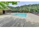 Community pool with a covered picnic table, metal fence, and surrounded by tall pine trees at 2505 Thackery Ct, Cumming, GA 30041