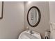 Compact powder room featuring a pedestal sink, oval mirror, and neutral decor at 2505 Thackery Ct, Cumming, GA 30041
