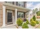 Inviting front porch with decorative columns, well-maintained landscaping, and a charming 'Home Sweet Home' sign at 3868 Sweet Iris Cir, Loganville, GA 30052