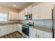 Modern kitchen featuring white cabinets, granite counters, a stainless steel stove, and tiled backsplash at 3868 Sweet Iris Cir, Loganville, GA 30052