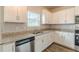 Well-lit kitchen featuring white cabinets, granite countertops, stainless steel appliances, and a large sink at 3868 Sweet Iris Cir, Loganville, GA 30052