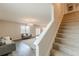 Open-concept living room with a modern chandelier, sleek gray sofas, and elegant staircase with plush carpeting at 3868 Sweet Iris Cir, Loganville, GA 30052