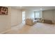 Carpeted loft area with neutral sectional, ottoman, and a doorway leading to another room at 3868 Sweet Iris Cir, Loganville, GA 30052