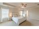Inviting bedroom with tray ceilings, a ceiling fan, large windows, and an ensuite entrance at 3868 Sweet Iris Cir, Loganville, GA 30052
