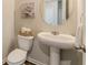 Cozy powder room with a pedestal sink, oval mirror, and neutral wall art at 3868 Sweet Iris Cir, Loganville, GA 30052