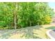A grassy backyard with trees, partially enclosed by a stone border at 674 Chadmon Court Trce, Dacula, GA 30019