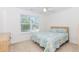 Bright bedroom featuring a window, ceiling fan, plush carpet, and comfortable furnishings at 674 Chadmon Court Trce, Dacula, GA 30019