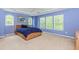 Spacious bedroom with blue walls, large windows, plush carpeting, and a tray ceiling with a ceiling fan at 674 Chadmon Court Trce, Dacula, GA 30019