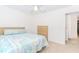 Bright bedroom features a window, ceiling fan, plush carpet, and comfortable furnishings at 674 Chadmon Court Trce, Dacula, GA 30019
