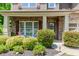 Inviting covered front porch showcases a stone facade, rocking chairs, and manicured landscaping at 674 Chadmon Court Trce, Dacula, GA 30019