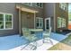 Outdoor patio area with green metal table and chairs, plus views of the well-maintained lawn and siding at 674 Chadmon Court Trce, Dacula, GA 30019