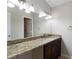 Bright bathroom featuring granite counters, vanity cabinet, and a large mirror with vanity lighting at 102 River Oaks Dr, Woodstock, GA 30188