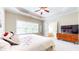 Spacious main bedroom with ceiling fan, tray ceiling, ensuite bathroom, and dresser with TV at 1263 Linden Ne Ct, Atlanta, GA 30329