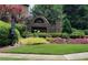 Stone entrance to Howell Farms neighborhood with manicured landscaping and American flags at 2269 Howell Farms Nw Trl, Acworth, GA 30101
