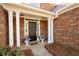 Inviting front porch with flower pots, pillars, and a welcome mat at 2269 Howell Farms Nw Trl, Acworth, GA 30101