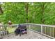 Cozy outdoor deck featuring a grill and lush trees in the background, perfect for relaxing or entertaining guests at 2585 Whisper Trail, Douglasville, GA 30135