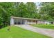 View of the house exterior with a long driveway and carport amid lush greenery at 2585 Whisper Trail, Douglasville, GA 30135