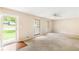 Bright living room featuring an open doorway, neutral walls, plush carpeting, and natural light from the windows at 2585 Whisper Trail, Douglasville, GA 30135