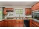 The kitchen features granite counters, wood cabinets, stainless steel appliances, and a window overlooking the backyard at 2623 Riggs Dr, Atlanta, GA 30344
