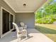 Relaxing covered patio with two white rocking chairs overlooking a beautifully landscaped backyard at 316 Denali Butte Ter, Canton, GA 30114