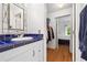 Stylish bathroom vanity features blue tile countertop, mirror and closet access at 1075 Peachtree Ne Walk # A204, Atlanta, GA 30309