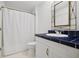 Bright bathroom with white marble tile, blue tile countertop, and tub shower combo at 1075 Peachtree Ne Walk # A204, Atlanta, GA 30309