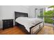 Bedroom with hardwood floors, balcony, and large bedframe at 1075 Peachtree Ne Walk # A204, Atlanta, GA 30309