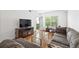 Bright living room area with hardwood floors, balcony, and large sectional sofa at 1075 Peachtree Ne Walk # A204, Atlanta, GA 30309