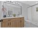 Modern bathroom featuring a double vanity with wood cabinets, a large mirror, and a tiled shower, exuding elegance at 1766 Blossom Ln, Austell, GA 30168