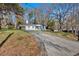 Long driveway leading up to a cozy home with a carport and front porch, surrounded by trees at 1766 Blossom Ln, Austell, GA 30168