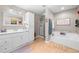 Well-lit bathroom featuring a large vanity, shower and a soaking tub with cabinets at 1822 Morgan Rd, Canton, GA 30115