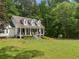 Charming two-story home with inviting front porch, stone chimney, and lush landscaping at 1822 Morgan Rd, Canton, GA 30115