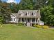 Charming two-story home with inviting front porch, stone chimney, and lush landscaping at 1822 Morgan Rd, Canton, GA 30115