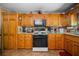 Well-lit kitchen featuring wood cabinets, granite counters, and modern appliances at 1822 Morgan Rd, Canton, GA 30115
