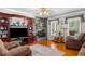 Comfortable living room featuring a stone fireplace, wooden built-ins and hardwood flooring, creating a warm atmosphere at 1822 Morgan Rd, Canton, GA 30115