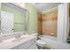 Bathroom with a shower-tub combo, large mirror, and green walls at 5415 Old Haven Ct, Cumming, GA 30041