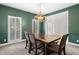 Elegant dining room features green accent wall, white trim, and stylish light fixture above wood table at 5415 Old Haven Ct, Cumming, GA 30041