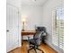 Bright home office has hardwood floors, black rolling chair, and bright natural light from shuttered window at 5415 Old Haven Ct, Cumming, GA 30041