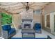 Cozy screened patio with a brick fireplace, comfortable seating, and charming string lights at 5415 Old Haven Ct, Cumming, GA 30041