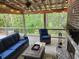 Cozy screened patio with a brick fireplace, comfortable seating, and charming string lights at 5415 Old Haven Ct, Cumming, GA 30041