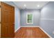 Small room with light blue walls, hardwood floors, and one small window at 5415 Old Haven Ct, Cumming, GA 30041