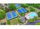 Aerial shot showcasing community tennis courts, a pool, clubhouse, and lush landscaping at 1943 Blue Heron Way, Lawrenceville, GA 30043