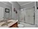 Clean bathroom with a shower/tub combo featuring a sliding glass door and a granite-look countertop at 1943 Blue Heron Way, Lawrenceville, GA 30043